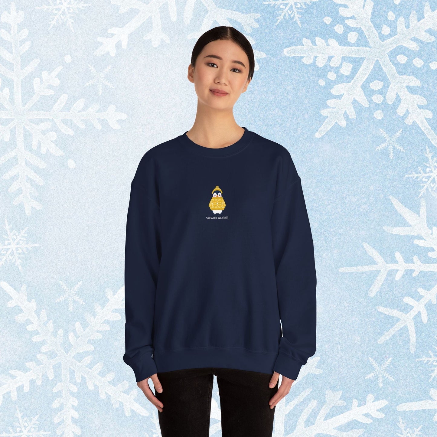 Sweater Weather Unisex Crewneck Sweatshirt - Staying Warm and Fuzzy. Small centered Penguin design wearing a yellow Sweater with text under "sweater weater"