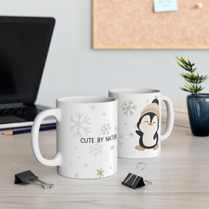 Penguin Mug - Cute Ceramic white mug with a cute penguin design wearing a winter hat. On the other side of the mug there is a text saying "Cute by nature".