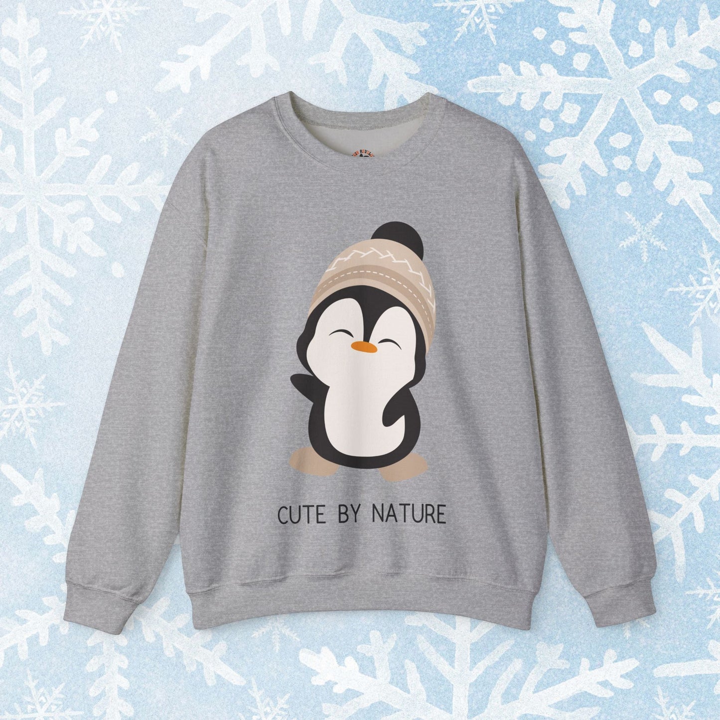 Cute Penguin Sweatshirt - Unisex Heavy Blend™ Crewneck, Cute by Nature, big cute winter penguin design, underneath a text "cute by nature"