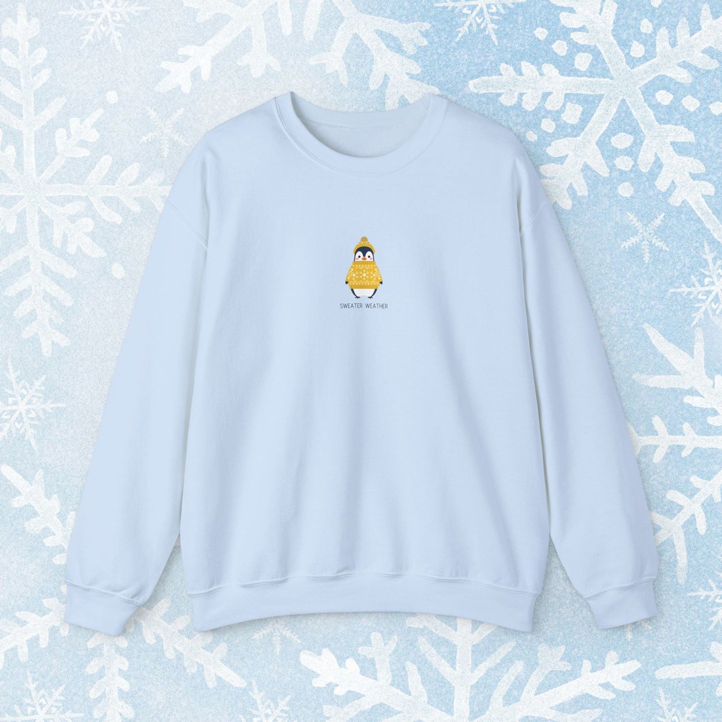 Sweater Weather Unisex Crewneck Sweatshirt - Staying Warm and Fuzzy. Small centered Penguin design wearing a yellow Sweater with text under "sweater weater"