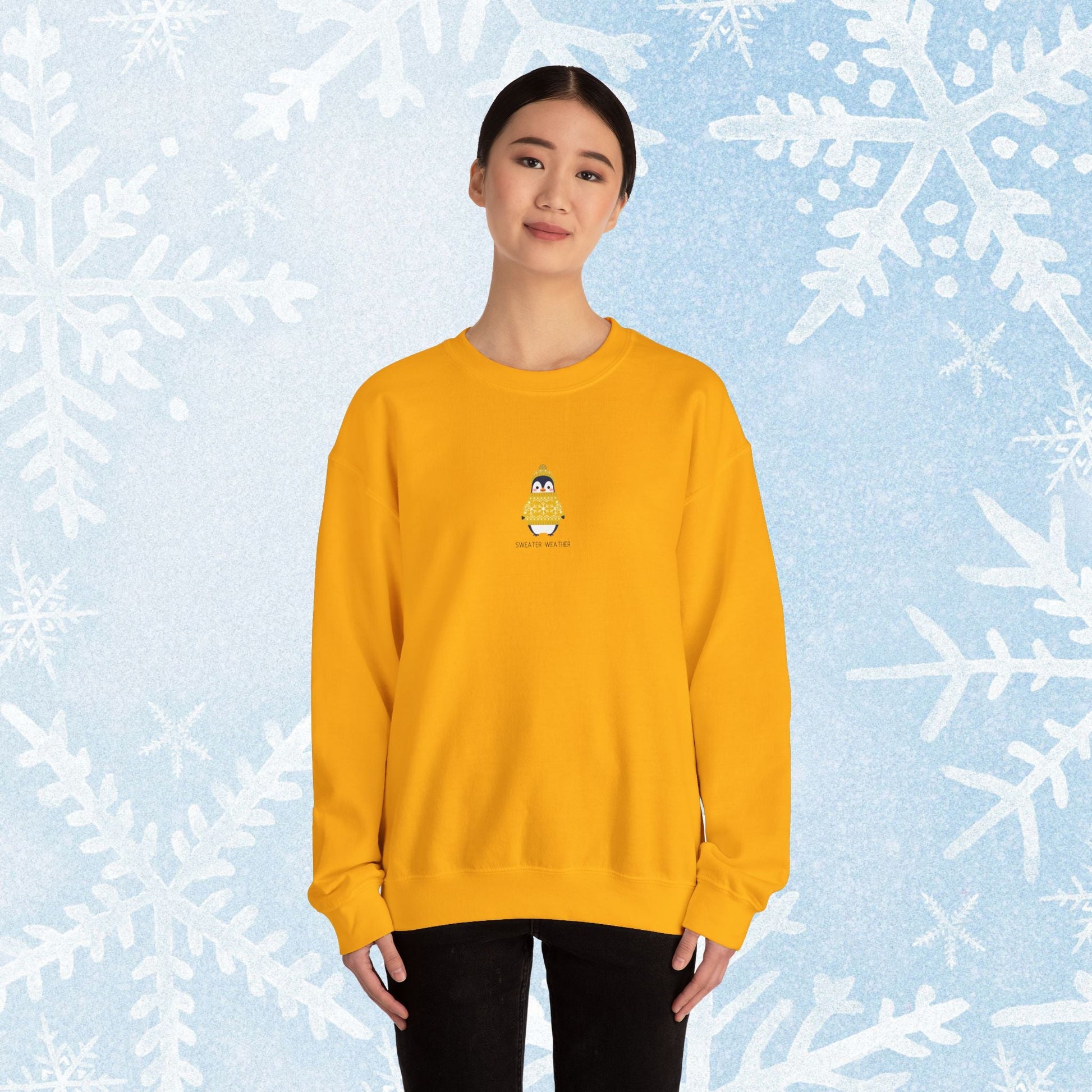 Sweater Weather Unisex Crewneck Sweatshirt - Staying Warm and Fuzzy. Small centered Penguin design wearing a yellow Sweater with text under "sweater weater"