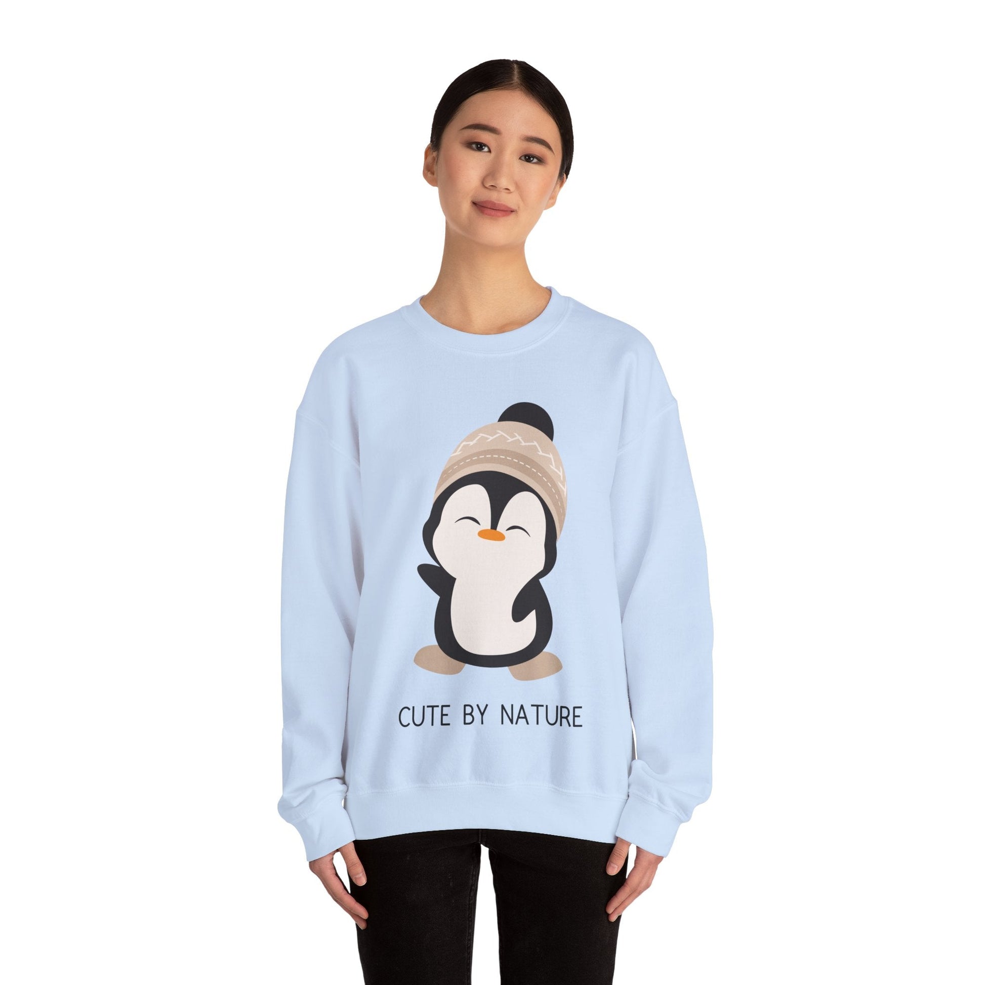 Cute Penguin Sweatshirt - Unisex Heavy Blend™ Crewneck, Cute by Nature, big cute winter penguin design, underneath a text "cute by nature"