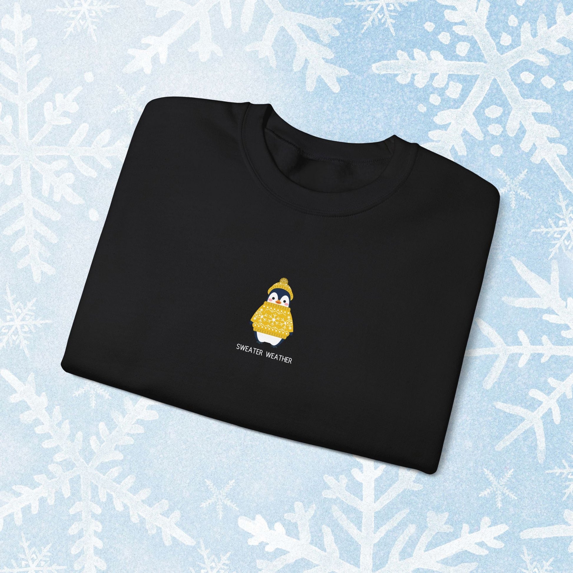 Sweater Weather Unisex Crewneck Sweatshirt - Staying Warm and Fuzzy. Small centered Penguin design wearing a yellow Sweater with text under "sweater weater"