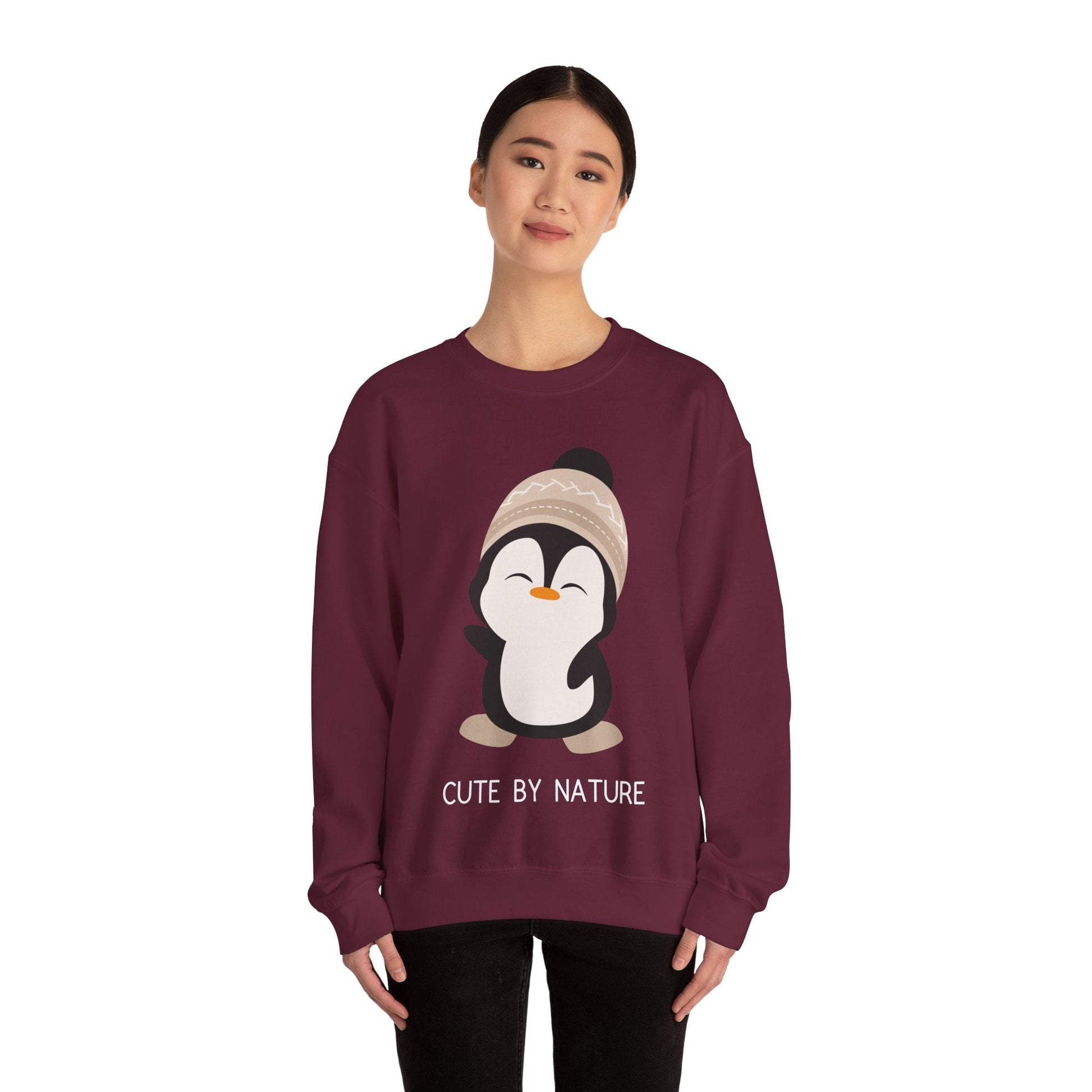 Cute Penguin Sweatshirt - Unisex Heavy Blend™ Crewneck, Cute by Nature, big cute winter penguin design, underneath a text "cute by nature"