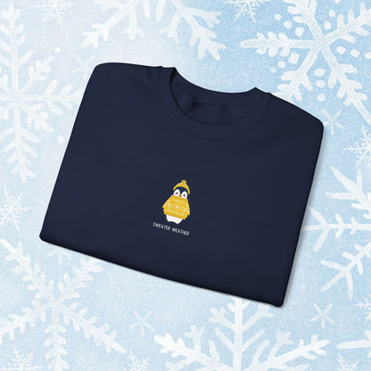 Sweater Weather Unisex Crewneck Sweatshirt - Staying Warm and Fuzzy. Small centered Penguin design wearing a yellow Sweater with text under "sweater weater"