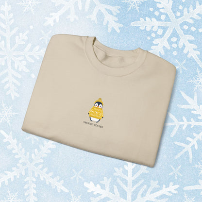 Sweater Weather Unisex Crewneck Sweatshirt - Staying Warm and Fuzzy. Small centered Penguin design wearing a yellow Sweater with text under "sweater weater"